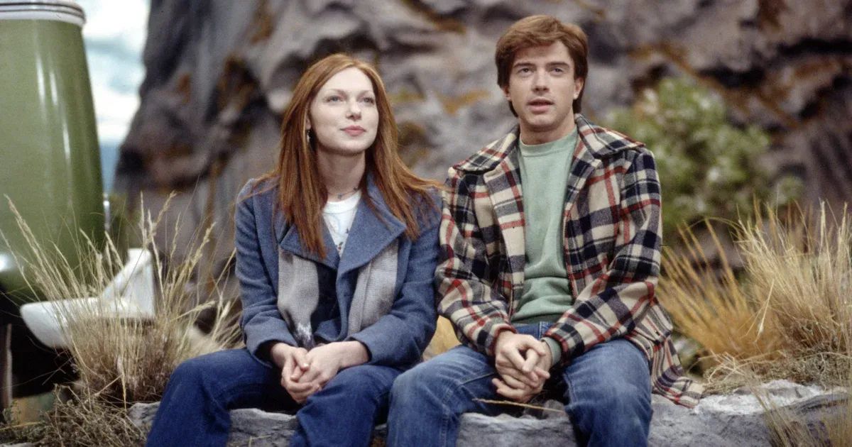 Eric and Donna sit on a rock in That 70s Show