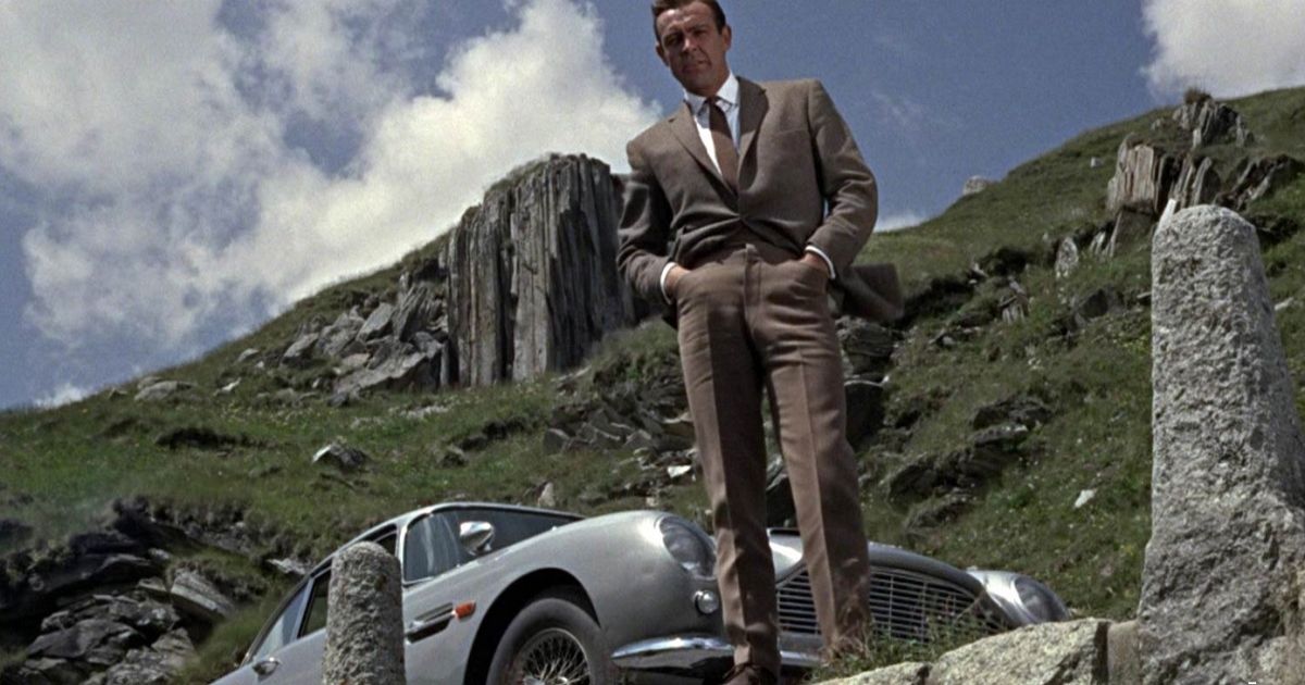 Sean Connery standing next to the Aston Martin DB5