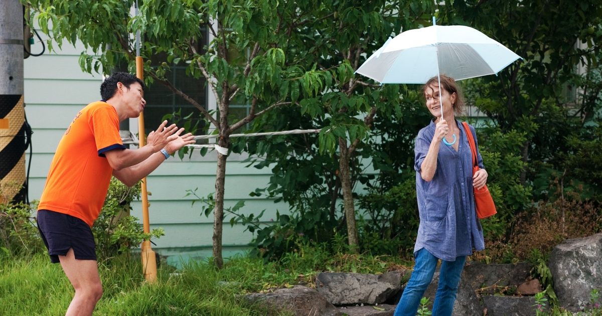 Man talks to woman as she holds umbrella up.