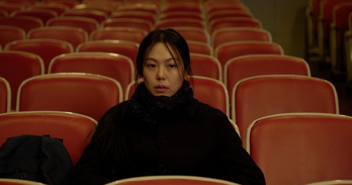 Woman sits alone in movie theater.