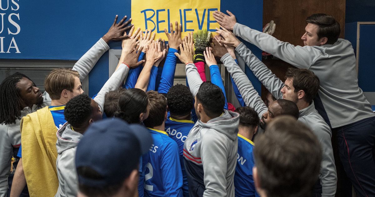 Ted Lasso cast and characters touch the Believe sign