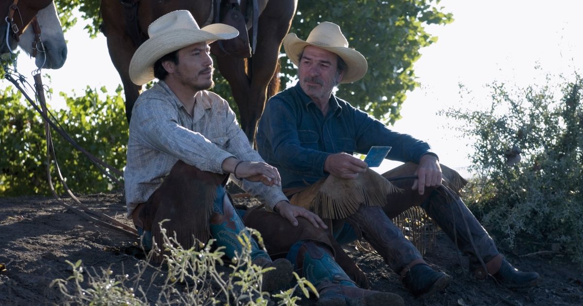 Two cowboys sitting on the ground in The Three Burials of Melquiades Estrada.