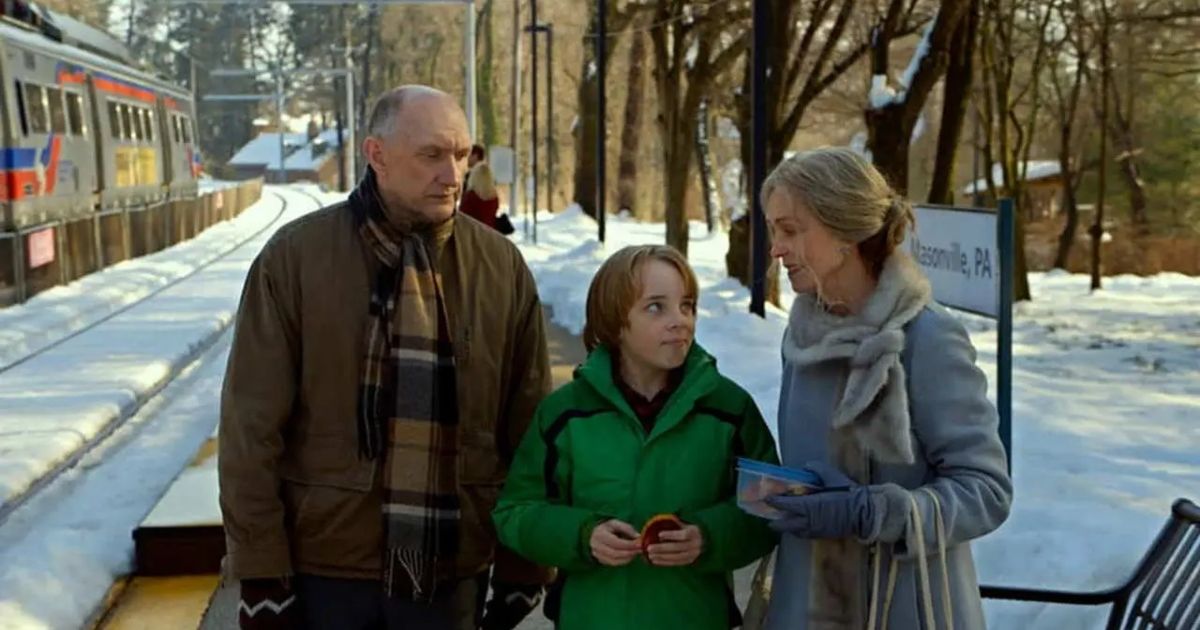 The grandparents stand with their grandson