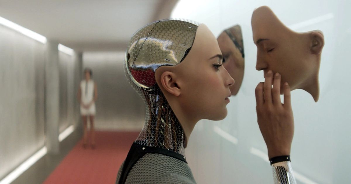 Ava in Ex Machina touching a synthesized face on the wall