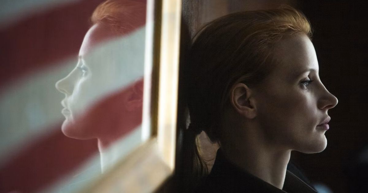 Jessica Chastain stands in front of the US flag in Zero Dark Thirty