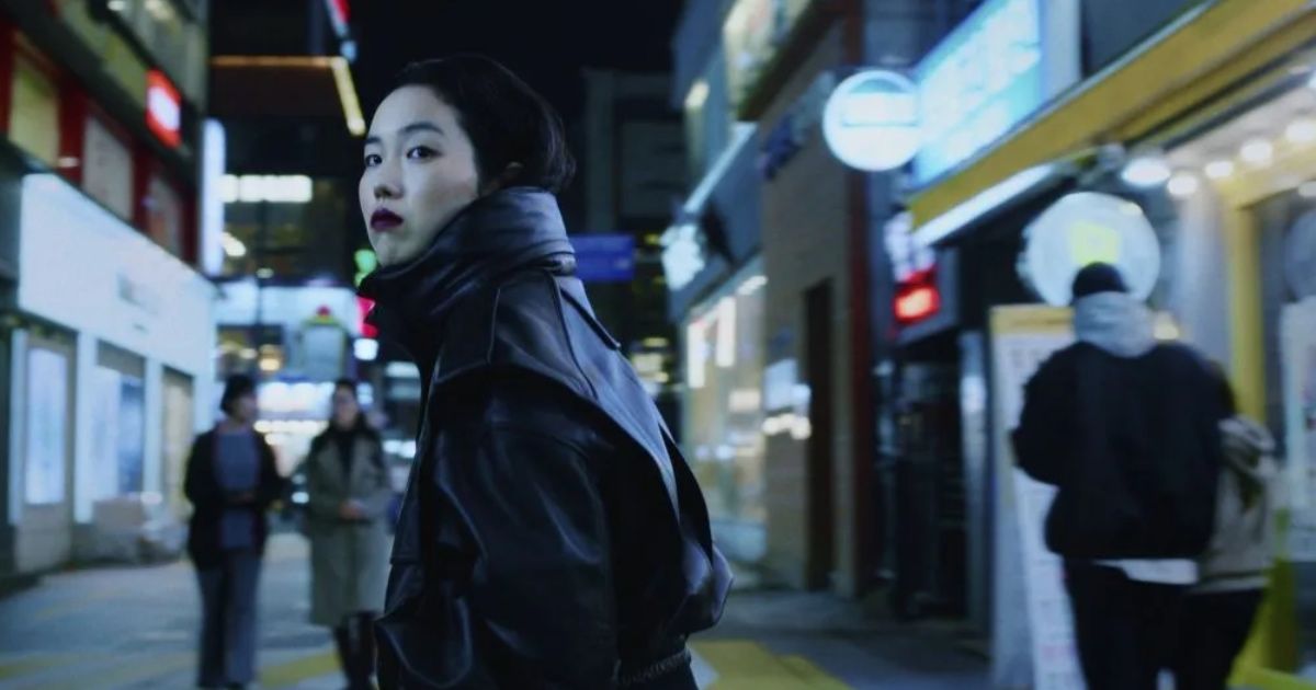 Woman walks through streets of Seoul at night in a leather jacket in Return to Seoul