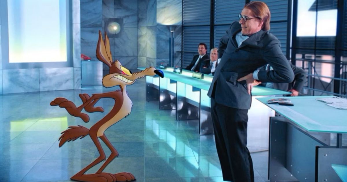 Wile E Coyote and Steve Martin standing in a shiny executive office with workers in suits in Looney Tunes Back In Action
