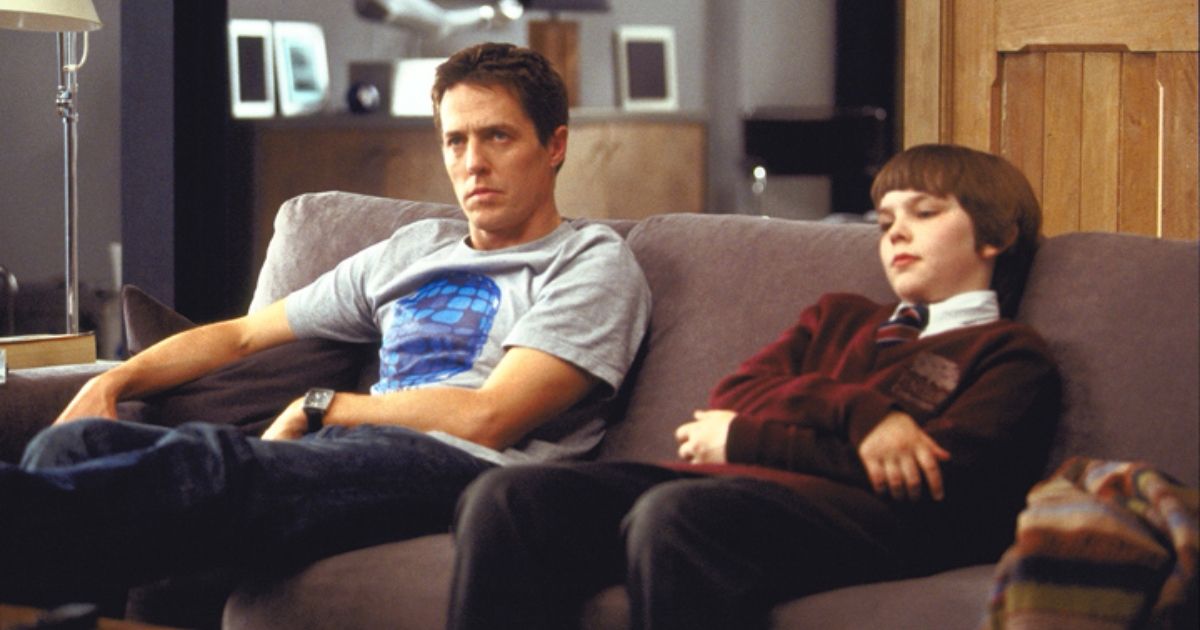Hugh Grant and Nicholas Hoult on the couch in About A Boy