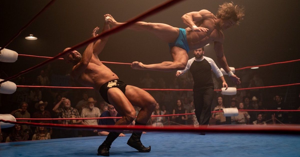 Zac Efron flying through the air in a wrestling ring in The Iron Claw.