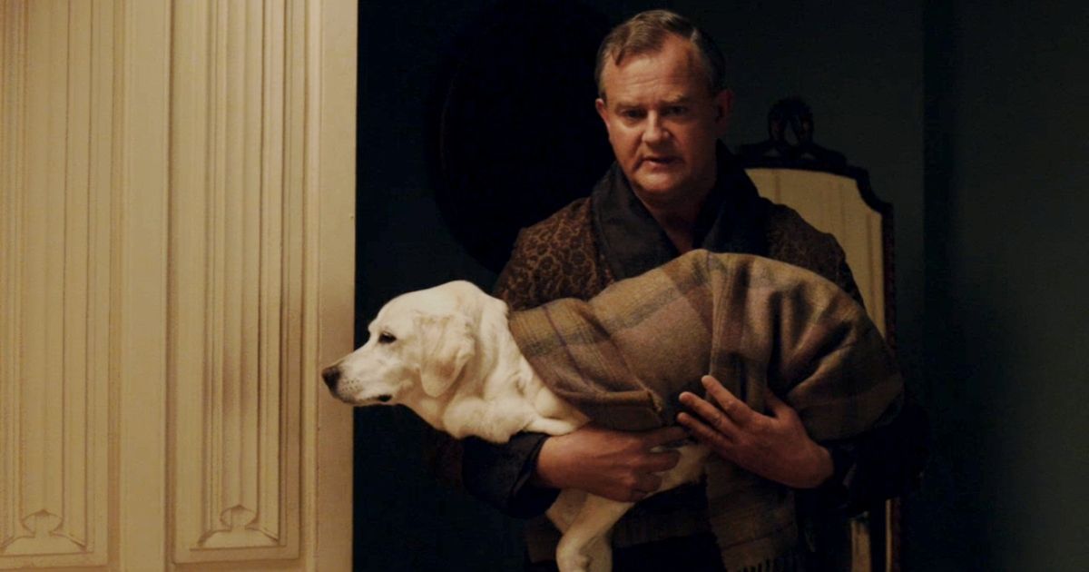 Hugh Bonneville in Downton Abbey holding the dog Isis