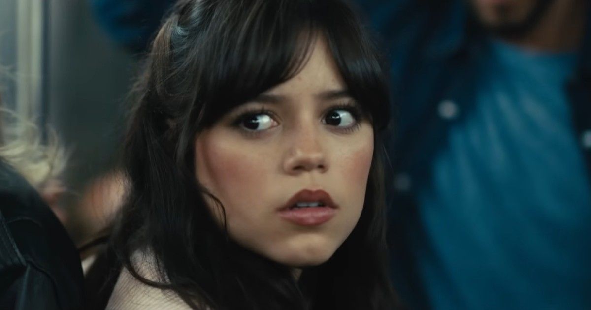 Jenna Ortega as Tera Carpenter in Scream VI on a subway train, looking at someone on the train with a scared expression