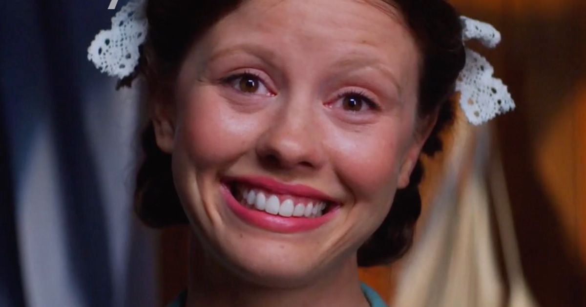 Mia Goth with a sinister smile and bows in her hair as Maxine / Pearl in Pearl.
