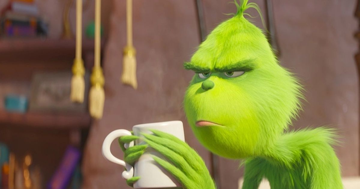 The Grinch being grouchy and holding a white mug