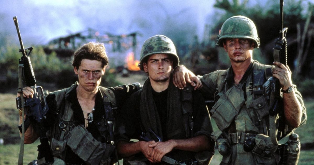 Three actors in Platoon dressed in military gear, dirty and beat up