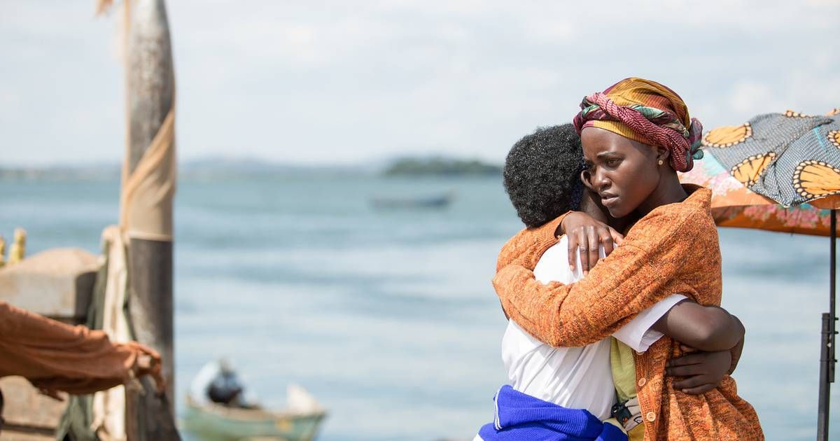 Two people hug next to the ocean