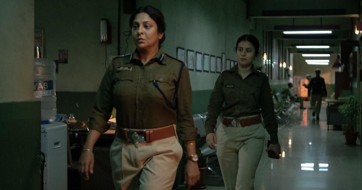 Two female police officers walk through hall