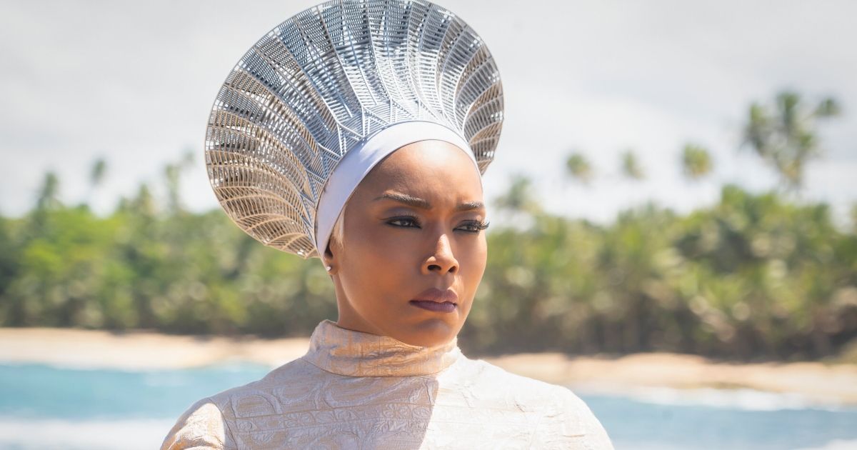 A woman in royal garb standing on a beach