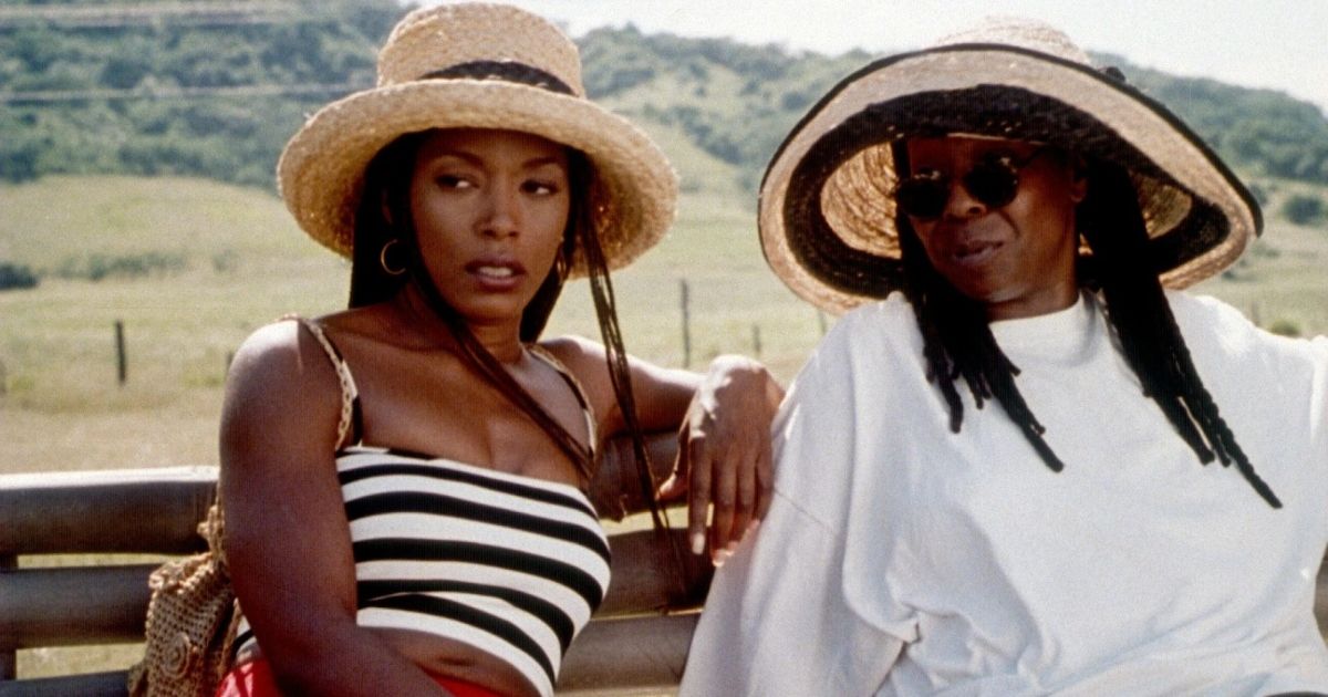 Two women in straw hats sitting on a bench