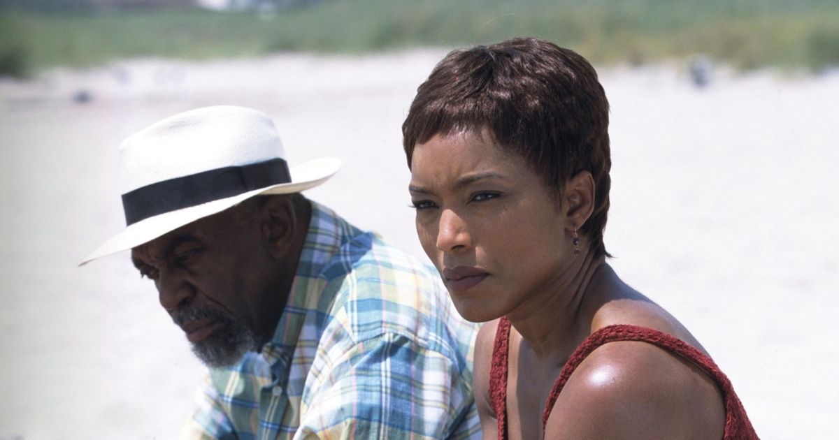 A woman and a man sitting on a beach under the bright sun