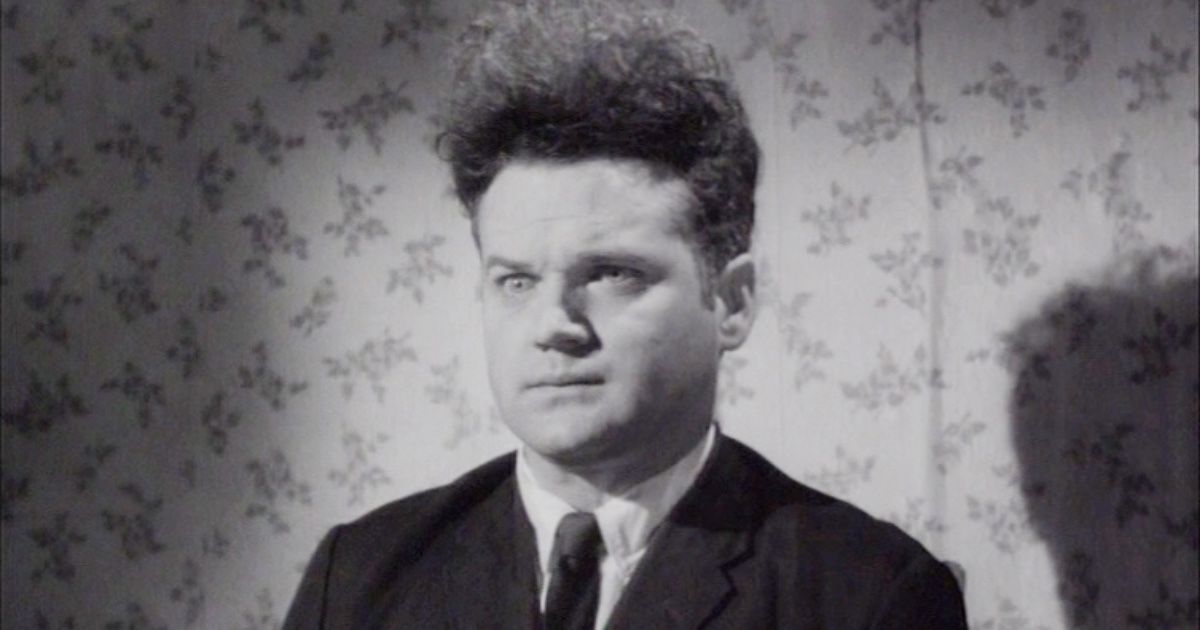 Eraserhead: A standing man with frizzy hair, a suit and a subtly crazed expression on his face