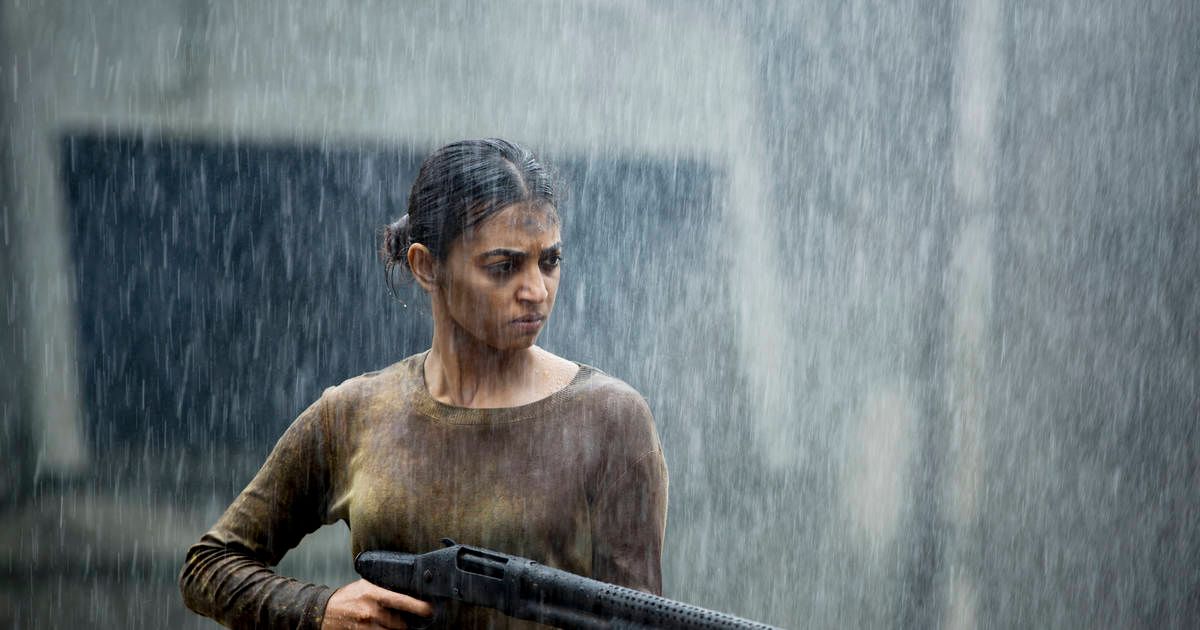 girl standing in the rain with a gun