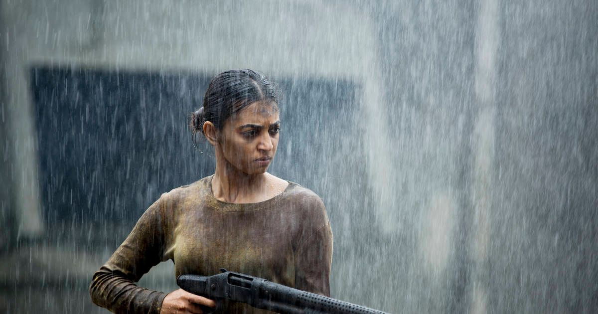 Girl stands in the rain with a gun