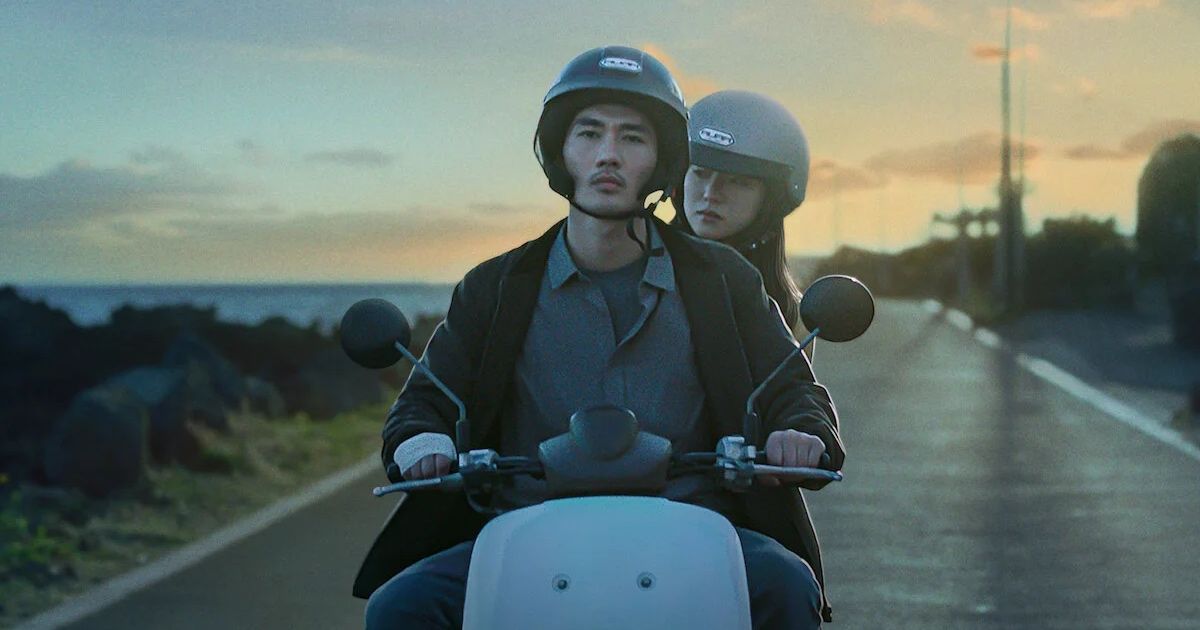 Man and woman ride motorcycle in sunset