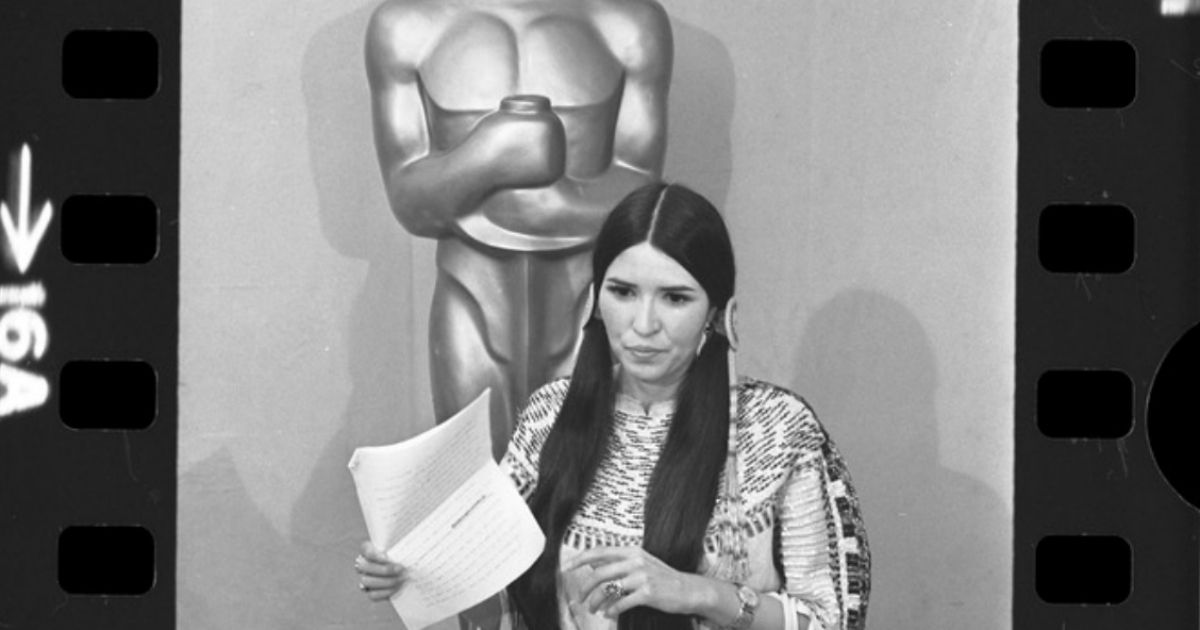 Sacheen Littlefeather standing before the Oscar statue holding Marlon Brando's statement at the 45th annual Academy Awards in Los Angeles.