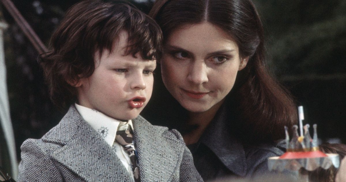 Harvey Stephens as Damien, dressed in nice clothes, playing with his toys and his nanny, Holly Palance, in The Omen