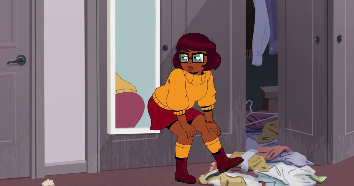 Velma looks at herself in the mirror