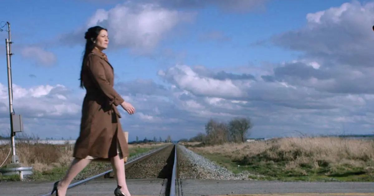 Woman crosses railroad tracks