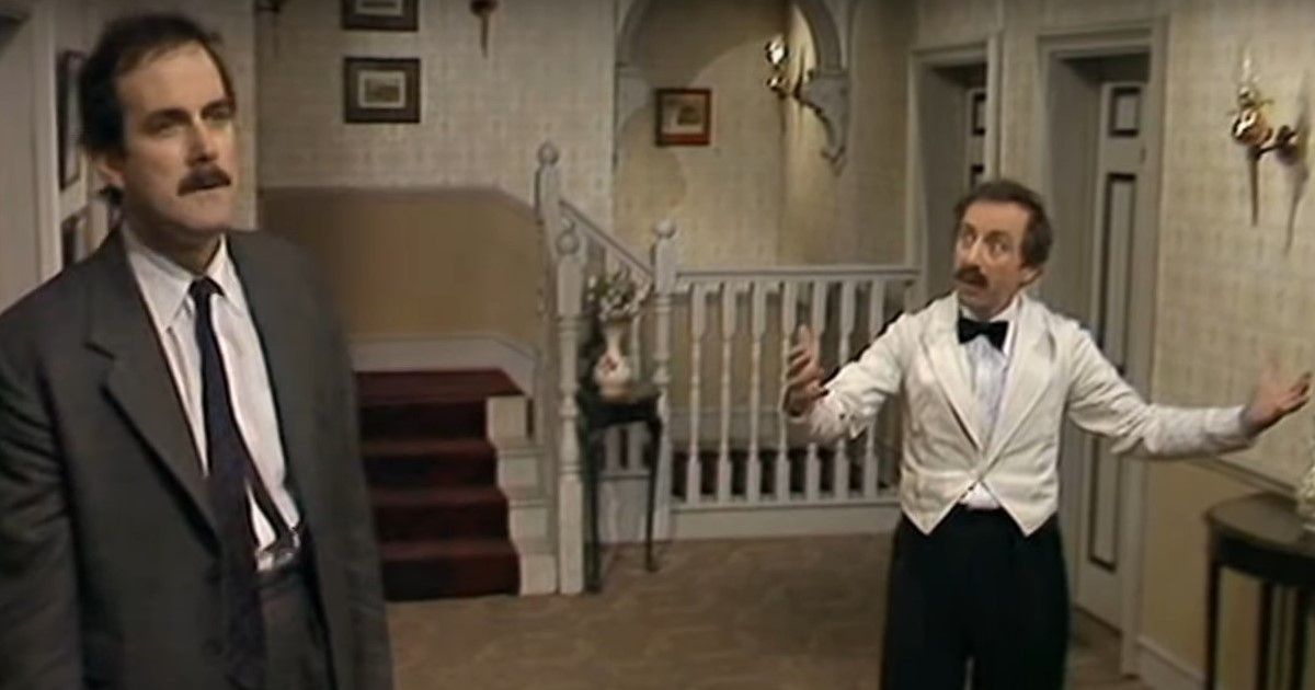 Basil and Manuel standing in a hotel hallway in Fawlty Towers