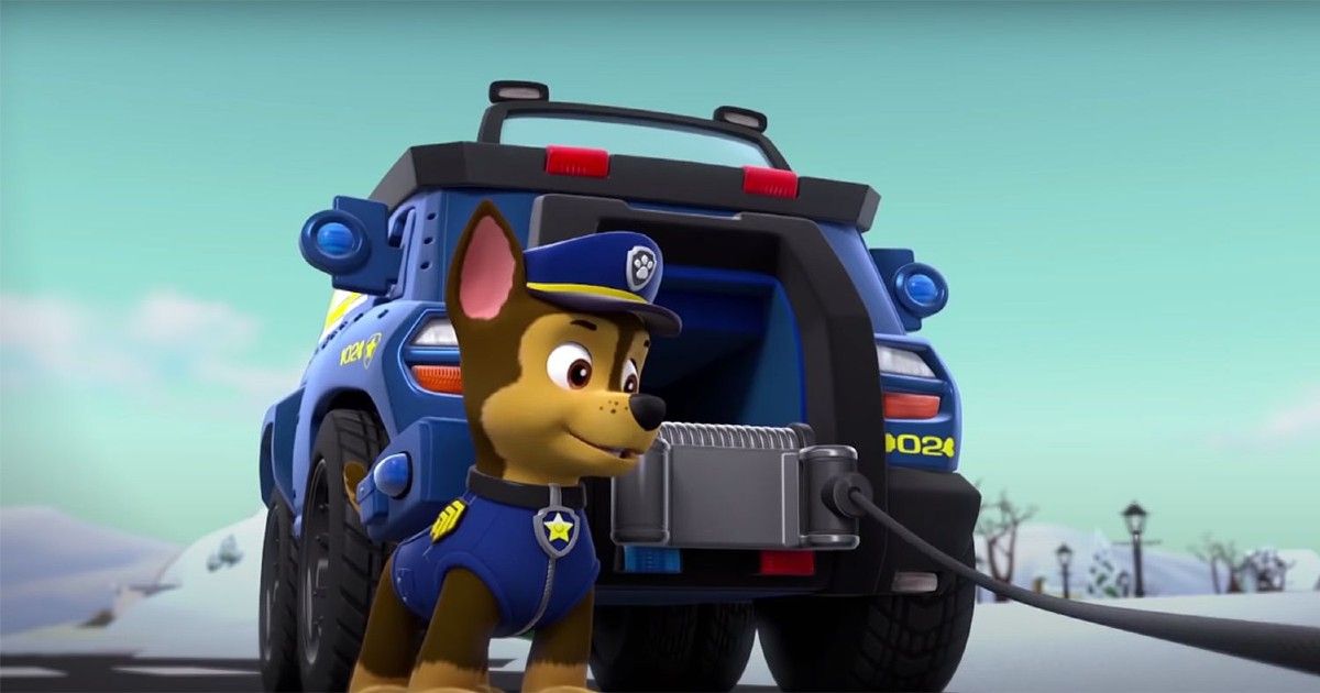 Chase from Paw Patrol is standing next to his truck.