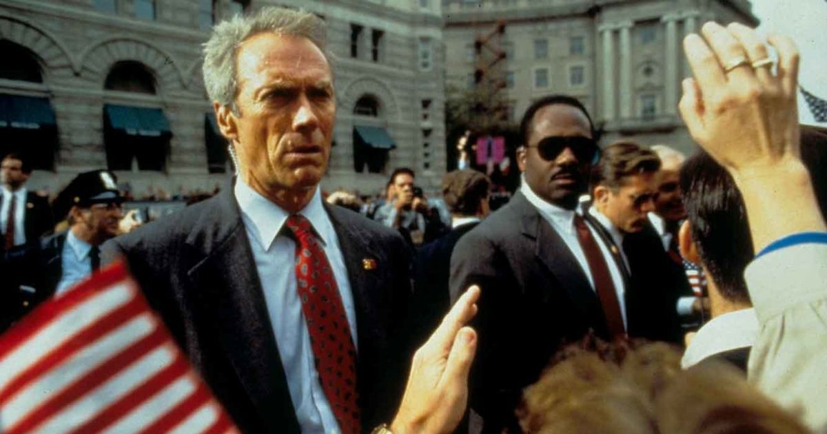 Clint Eastwood as Frank Horrigan standing as a barrier in front of a group of people