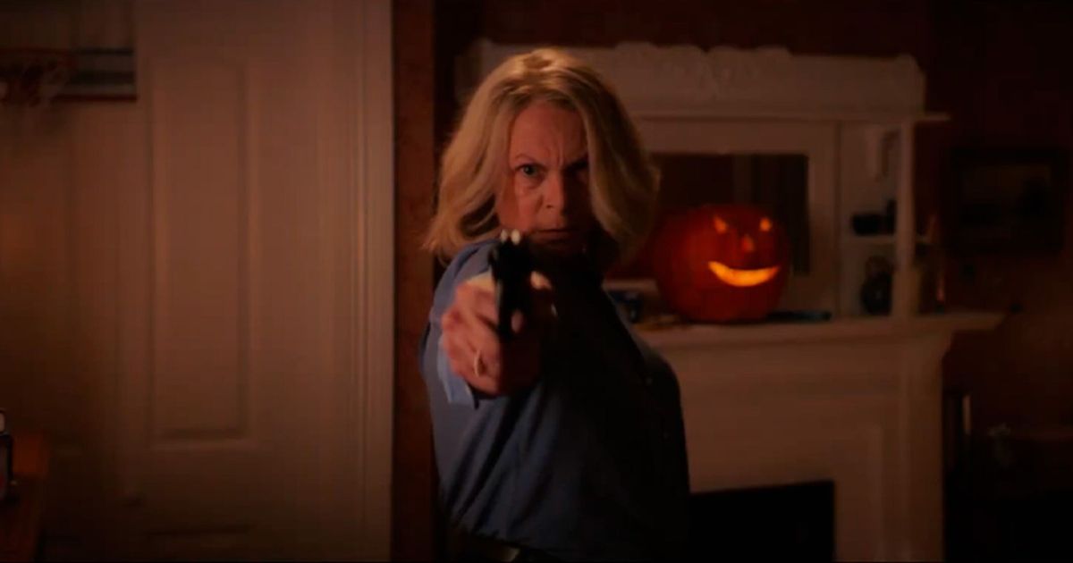 Jamie Lee Curtis as Laurie Strode pointing a gun in Halloween Ends