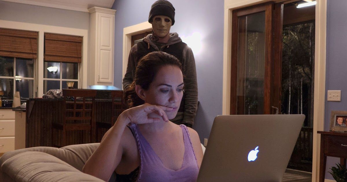Kate Siegel with an intruder behind her in silence