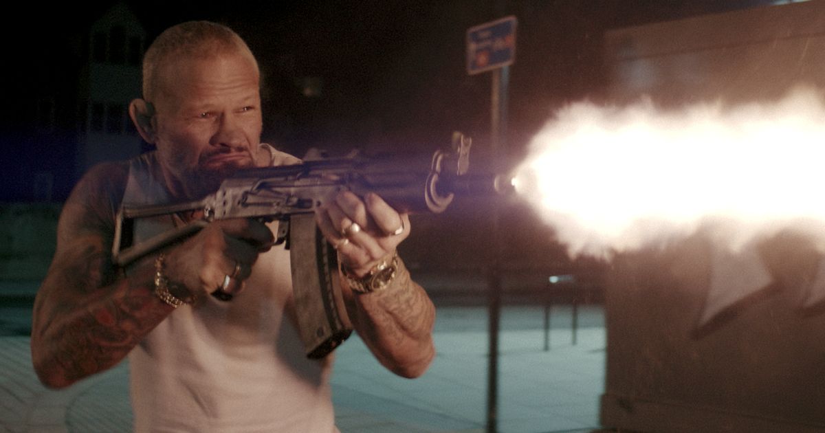 A thug firing an automatic rifle in the Lionsgate film One Ranger.