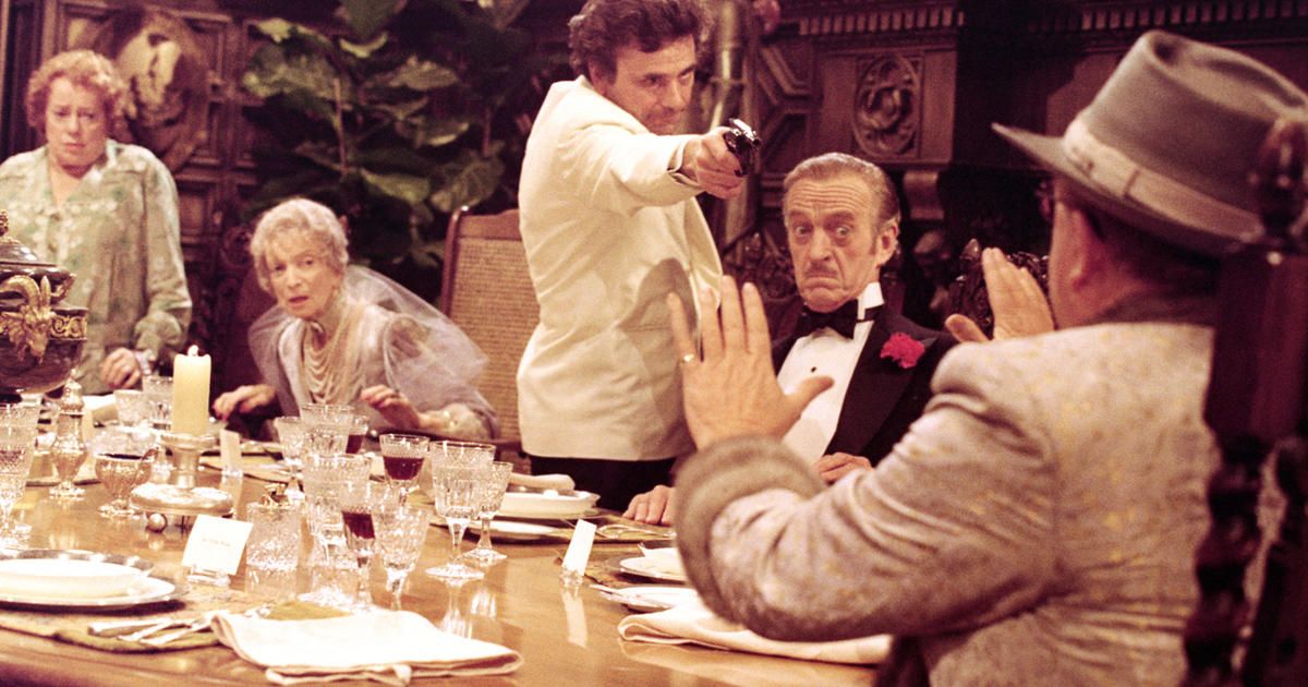 Peter Falk aims a gun at a dinner party in Murder by Death