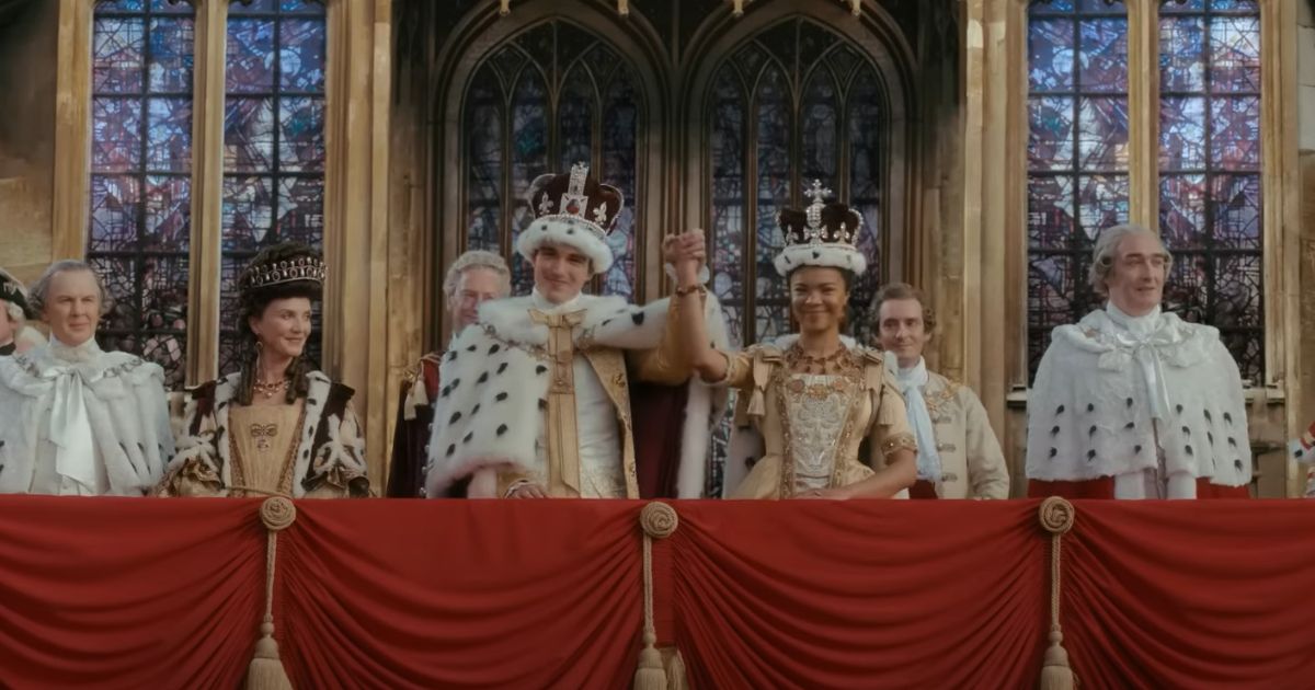 The newly coronated George and Charlotte greet the people from church balcony in Queen Charlotte: A Bridgerton Story