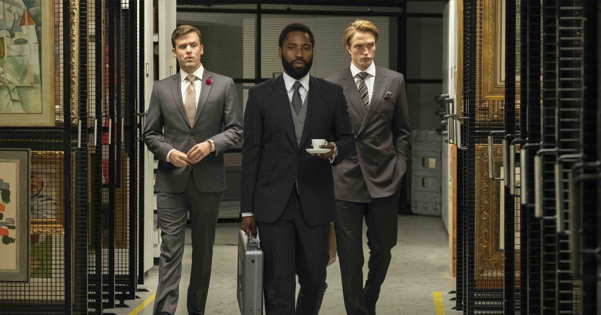 Three men walk down the hall in men's suits, carrying espresso and a briefcase