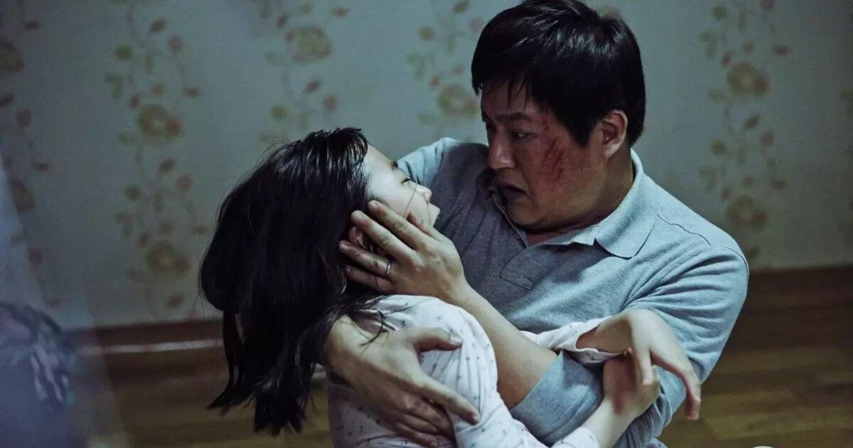 A father cradles his daughter in The Wailing