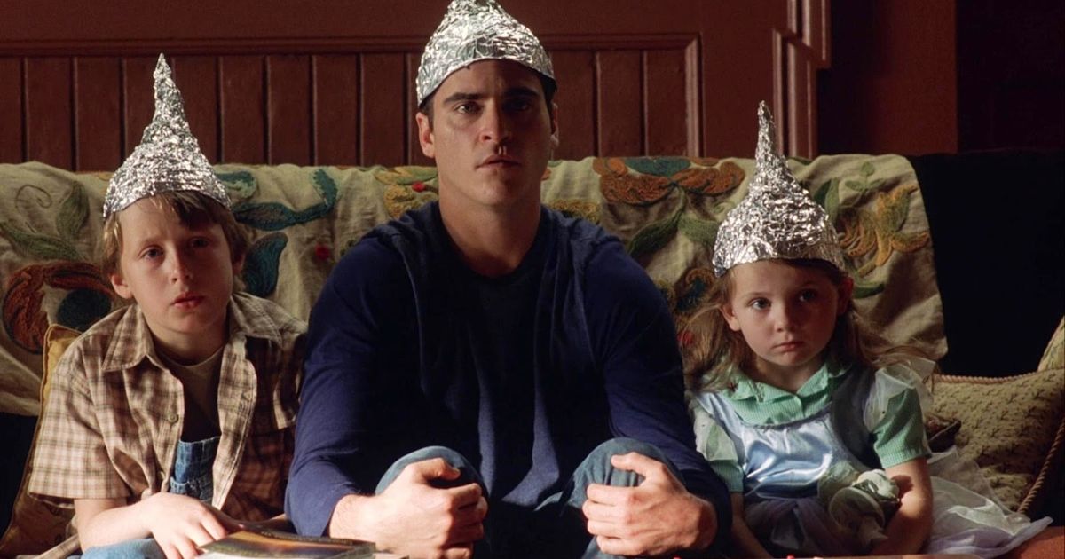 A man and two children wearing tinfoil hats from Signs