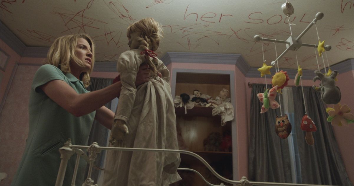 Wallis picks up the doll in scene from Annabelle 