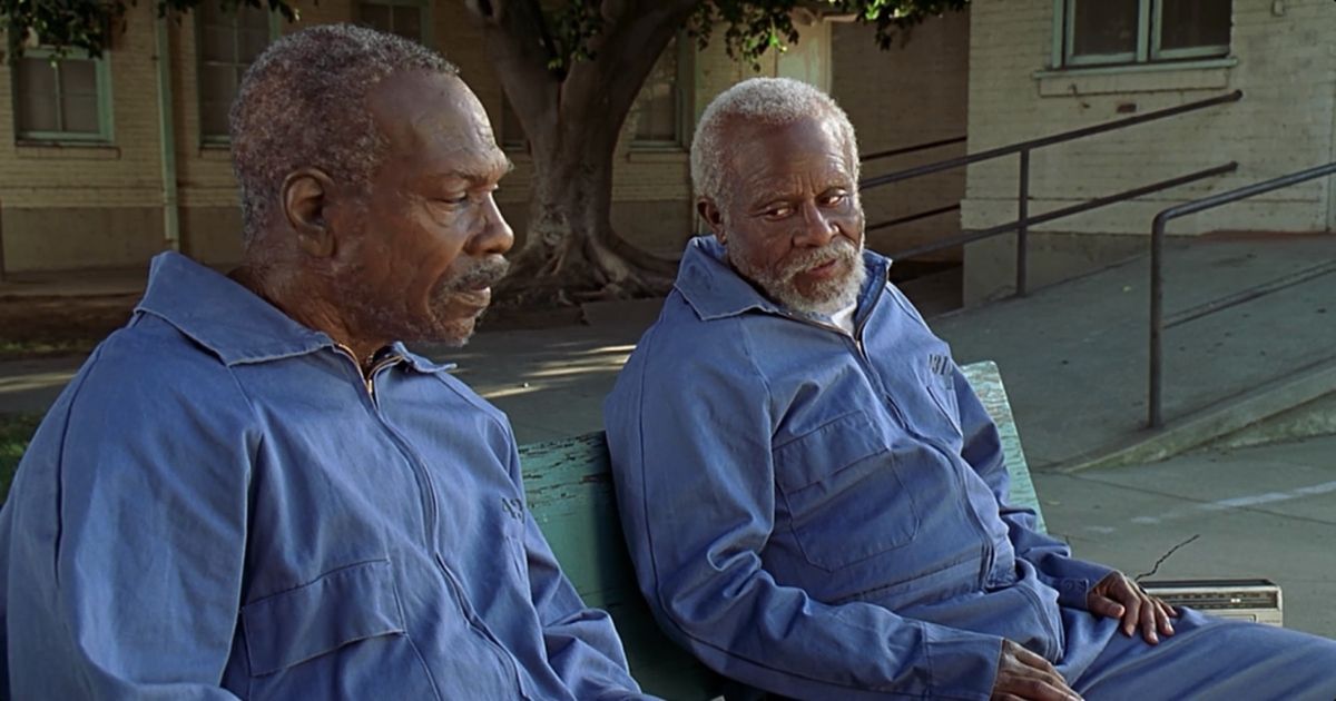 Eddie Murphy as Rayford Gibson and Martin Lawrence as Claude Banks sitting on a bench in Life (1999)