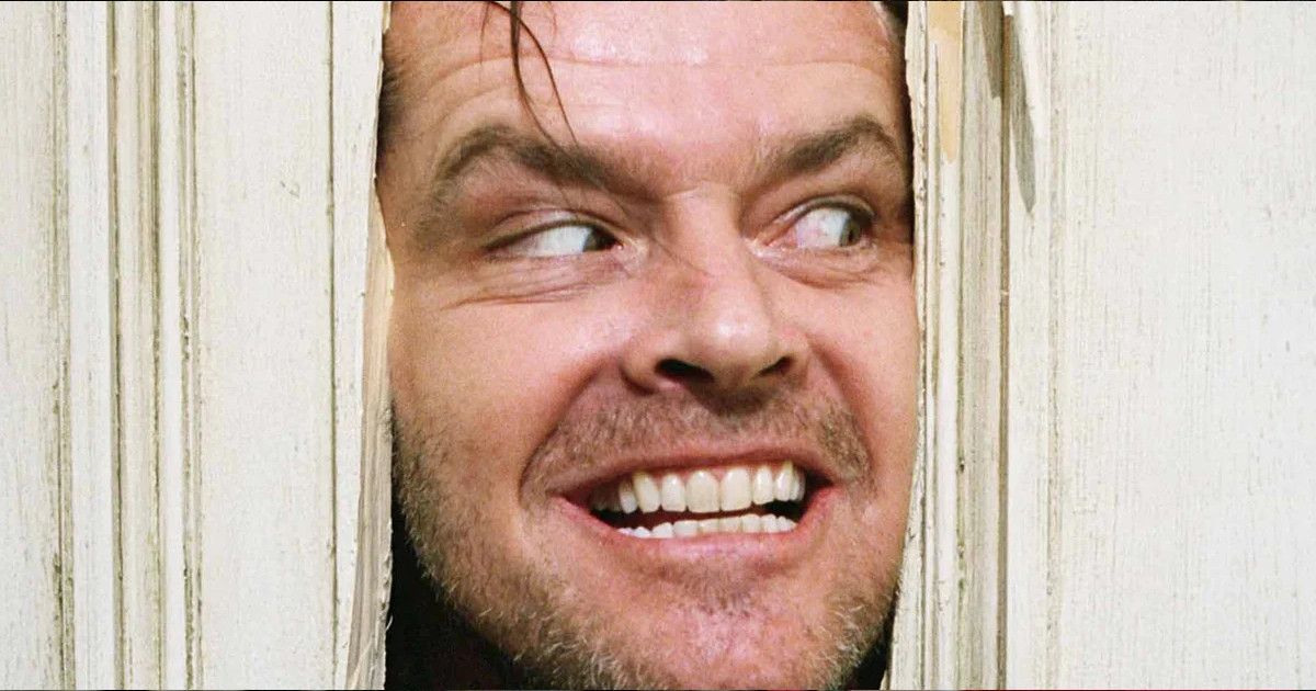 Jack Nicholson stares through the cracked door in The Shining