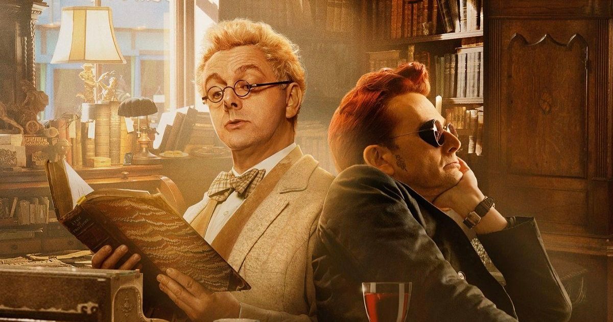 Michael Sheen & David Tennant in Good Omens wearing their respective light and dark colored outfits, reading a large book in an old room.