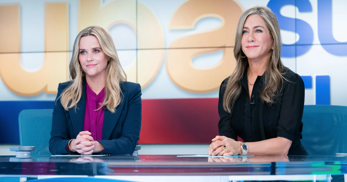 The Morning Show Jennifer Aniston and Reese Witherspoon sitting at a desk.