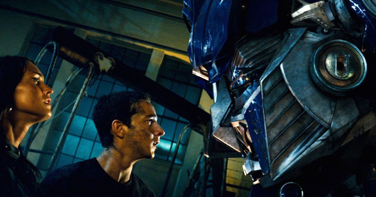 Sam and Mikaela stare up at Optimus Prime in transformers