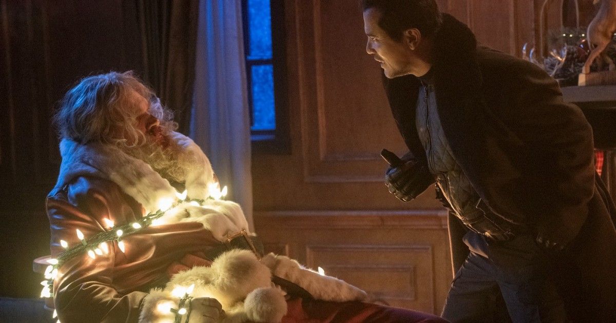 David Harbour as Santa tied up with Christmas lights. 