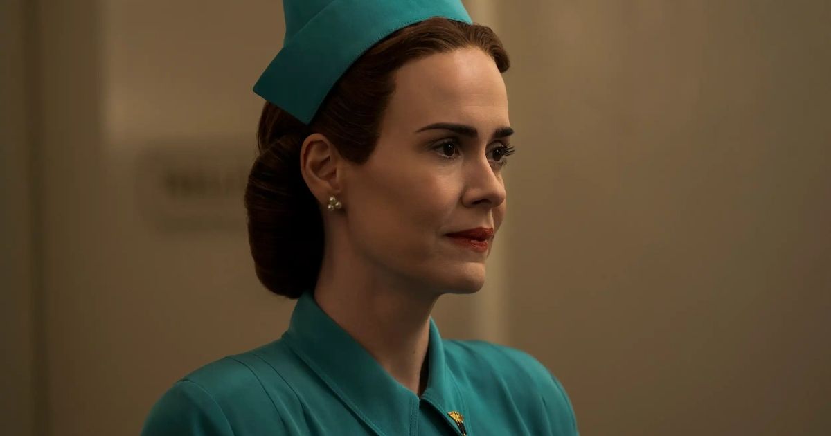 Sarah Paulson as Nurse Mildred Ratched dressed in a green outfit with a matching hat, looking at something off-camera. 
